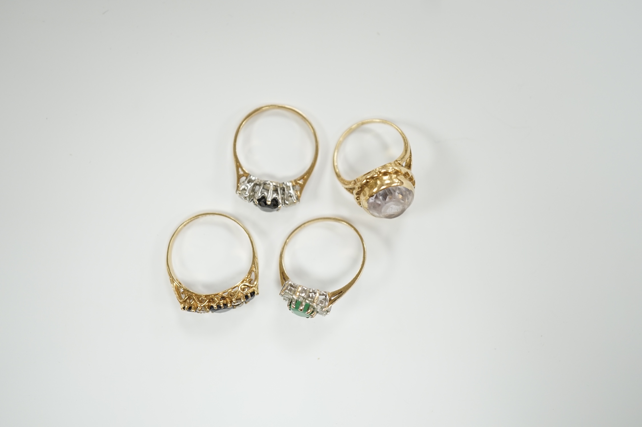 Four assorted modern 9ct gold and gem set dress rings, including sapphire and simulated diamond, gross weight 9.9 grams.